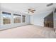 Bright bonus room featuring neutral carpet, ceiling fan, triple windows, and access to the upstairs hallway at 401 Nichols Dr, Suwanee, GA 30024