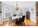 Dining room with hardwood floors, a modern chandelier, and lots of natural light from the large windows at 401 Nichols Dr, Suwanee, GA 30024