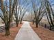 A long driveway lined with mature trees and fencing leads up to a charming home, creating a sense of privacy and exclusivity at 401 Nichols Dr, Suwanee, GA 30024