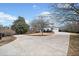 Long driveway leading to a white home with a well-manicured front yard and mature trees at 401 Nichols Dr, Suwanee, GA 30024
