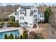 Stunning white home featuring a swimming pool, lush landscaping, and a charming outdoor seating area at 401 Nichols Dr, Suwanee, GA 30024