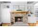 Close up of the stone fireplace with built in shelving and hardwood floors in the living room at 401 Nichols Dr, Suwanee, GA 30024