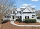 Inviting exterior view features a well-maintained lawn, complemented by a charming covered porch and elegant architectural details at 401 Nichols Dr, Suwanee, GA 30024