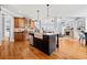 Open kitchen with hardwood floors, an island with a farmhouse sink, stainless steel appliances, and custom cabinets at 401 Nichols Dr, Suwanee, GA 30024