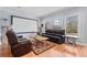 Bright living room with hardwood floors, a projector screen, and large windows at 401 Nichols Dr, Suwanee, GA 30024