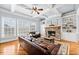 Bright living room with a stone fireplace, hardwood floors, built-in shelving, and coffered ceilings at 401 Nichols Dr, Suwanee, GA 30024
