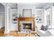 Inviting living room featuring a stone fireplace, built-in bookshelves, and hardwood floors at 401 Nichols Dr, Suwanee, GA 30024