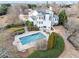 Aerial view of a luxury home with a stunning backyard pool and well-manicured landscaping and a horse in the field at 401 Nichols Dr, Suwanee, GA 30024