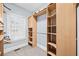 Spacious walk-in closet featuring custom wood shelving, rod, and a sunlit window at 401 Nichols Dr, Suwanee, GA 30024