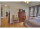 Bedroom features a decorative chair, rich wood floors, and natural light from the window at 491 Princeton Ne Way, Atlanta, GA 30307