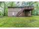 Home featuring an expansive backyard with lush greenery, deck, and stairs at 5802 Oakleaf Dr, Stone Mountain, GA 30087