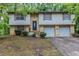 Split-level home with brick and siding, featuring an attached two-car garage and front yard at 5802 Oakleaf Dr, Stone Mountain, GA 30087