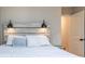 Bedroom featuring a gray-washed wooden headboard with modern sconces and white bedding at 955 Coleman Sw St, Atlanta, GA 30310