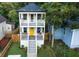 Two-story home featuring double porches, a bright yellow front door, and lush landscaping at 955 Coleman Sw St, Atlanta, GA 30310