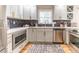 Updated kitchen featuring stainless steel appliances, gray cabinets with gold hardware, and black and white backsplash at 955 Coleman Sw St, Atlanta, GA 30310