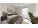 Comfortable bedroom with neutral decor, a plush bed, side tables, lamps, and a bright window at 175 Silverton Dr, Dacula, GA 30019