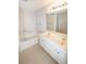 Bright bathroom with a double sink vanity, a soaking tub, and a large mirror at 2263 Leicester Se Way, Atlanta, GA 30316
