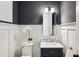 Stylish bathroom with dark gray accent wall, marble sink, and white wainscoting at 331 Peachtree Ne Ave, Atlanta, GA 30305