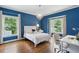 This bedroom features hardwood floors, blue walls, a white bed frame and a chandelier at 331 Peachtree Ne Ave, Atlanta, GA 30305