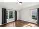 Bright bedroom features hardwood floors, large windows and dark grey curtains at 331 Peachtree Ne Ave, Atlanta, GA 30305