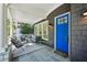 Covered front porch with seating, outdoor rug, slate flooring, and a blue front door at 331 Peachtree Ne Ave, Atlanta, GA 30305