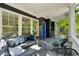 Covered front porch with comfortable seating, outdoor rug, and blue front door at 331 Peachtree Ne Ave, Atlanta, GA 30305