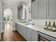 Gourmet kitchen with grey cabinets, wine cooler, quartz countertop, and subway tile backsplash at 331 Peachtree Ne Ave, Atlanta, GA 30305