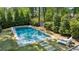 Beautiful backyard swimming pool surrounded by lush greenery, featuring lounge chairs for relaxation at 331 Peachtree Ne Ave, Atlanta, GA 30305