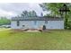 Rear of a home with outdoor seating and a lush green lawn at 8051 Trinity Park Dr, Riverdale, GA 30296
