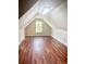 A spacious finished attic with wood flooring and a window allowing natural light into the room at 515 Sherwin Ct, Mcdonough, GA 30252