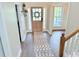 Bright foyer featuring a modern rug, light wood door, and staircase with white rails at 515 Sherwin Ct, Mcdonough, GA 30252