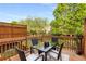 A wooden deck features outdoor seating with a glass table to enjoy the privacy of a treelined backyard at 833 Charles Bank Se Ave, Atlanta, GA 30312