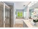 Well-lit bathroom features a tub, walk-in shower, neutral tile, and white cabinetry at 833 Charles Bank Se Ave, Atlanta, GA 30312