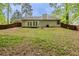 The backyard of the house is a mix of grass, trees, and a brown fence at 964 Chapman Ln, Stone Mountain, GA 30088