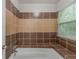 A tiled shower-tub combination shows neutral color tiles and a window with blinds at 964 Chapman Ln, Stone Mountain, GA 30088