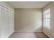 Carpeted bedroom featuring a closet and a window with blinds for privacy at 964 Chapman Ln, Stone Mountain, GA 30088
