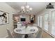 Virtually staged dining room features a marble table, modern chandelier, and view of the fireplace at 964 Chapman Ln, Stone Mountain, GA 30088