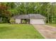 Well-maintained single-story home with a green lawn and a driveway leading to a garage at 964 Chapman Ln, Stone Mountain, GA 30088