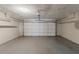 Empty garage with a white door, gray concrete floors, and an electric garage door opener at 964 Chapman Ln, Stone Mountain, GA 30088