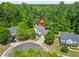 Aerial view of a residence nestled among mature trees in a well-landscaped neighborhood near a pond at 182 Garden Manor Ct, Loganville, GA 30052