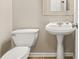 Compact bathroom featuring a pedestal sink, toilet, and neutral decor at 182 Garden Manor Ct, Loganville, GA 30052
