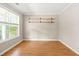 A bright, sunny room with wood floors, neutral walls, and minimalist decor with shelving at 182 Garden Manor Ct, Loganville, GA 30052