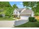 Charming two-story home with a well-maintained lawn and a paved driveway leading to an attached garage at 182 Garden Manor Ct, Loganville, GA 30052