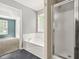 Bright main bathroom with a soaking tub, glass shower, and doorway to bedroom at 182 Garden Manor Ct, Loganville, GA 30052