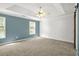 Spacious main bedroom with carpet flooring, board and batten accent wall, and large window at 182 Garden Manor Ct, Loganville, GA 30052