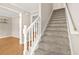 Carpeted stairs with white railing lead to the upper level, offering a seamless transition between floors at 182 Garden Manor Ct, Loganville, GA 30052