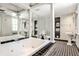 Stylish bathroom boasting a jacuzzi tub, black and white tiles, decorative columns, and ample mirror space at 2121 Ponce De Leon Ne Ave, Atlanta, GA 30307