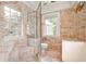 Elegant bathroom featuring marble walls and floors, glass-enclosed shower, and a window for natural light at 2121 Ponce De Leon Ne Ave, Atlanta, GA 30307