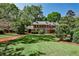 Captivating two-story brick home showcasing a lush green lawn, mature trees, and classic architectural details at 2121 Ponce De Leon Ne Ave, Atlanta, GA 30307