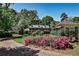 Beautiful brick home surrounded by colorful landscaped yard, flowering bushes and tall trees at 2121 Ponce De Leon Ne Ave, Atlanta, GA 30307